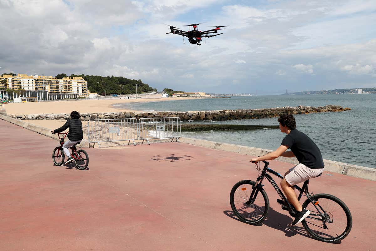 A drone with a loudspeaker warns people to respect social distancing rules in Portugal