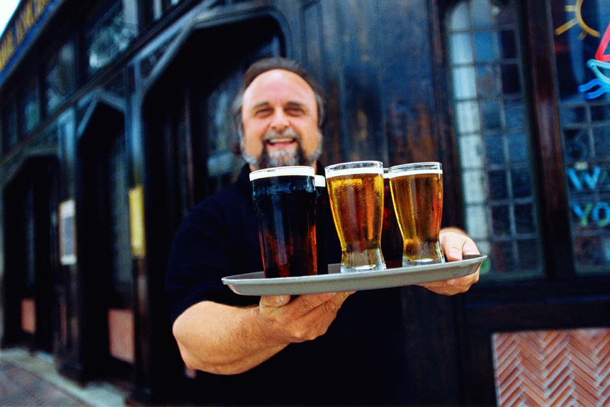 A pub owner with a tray of beers