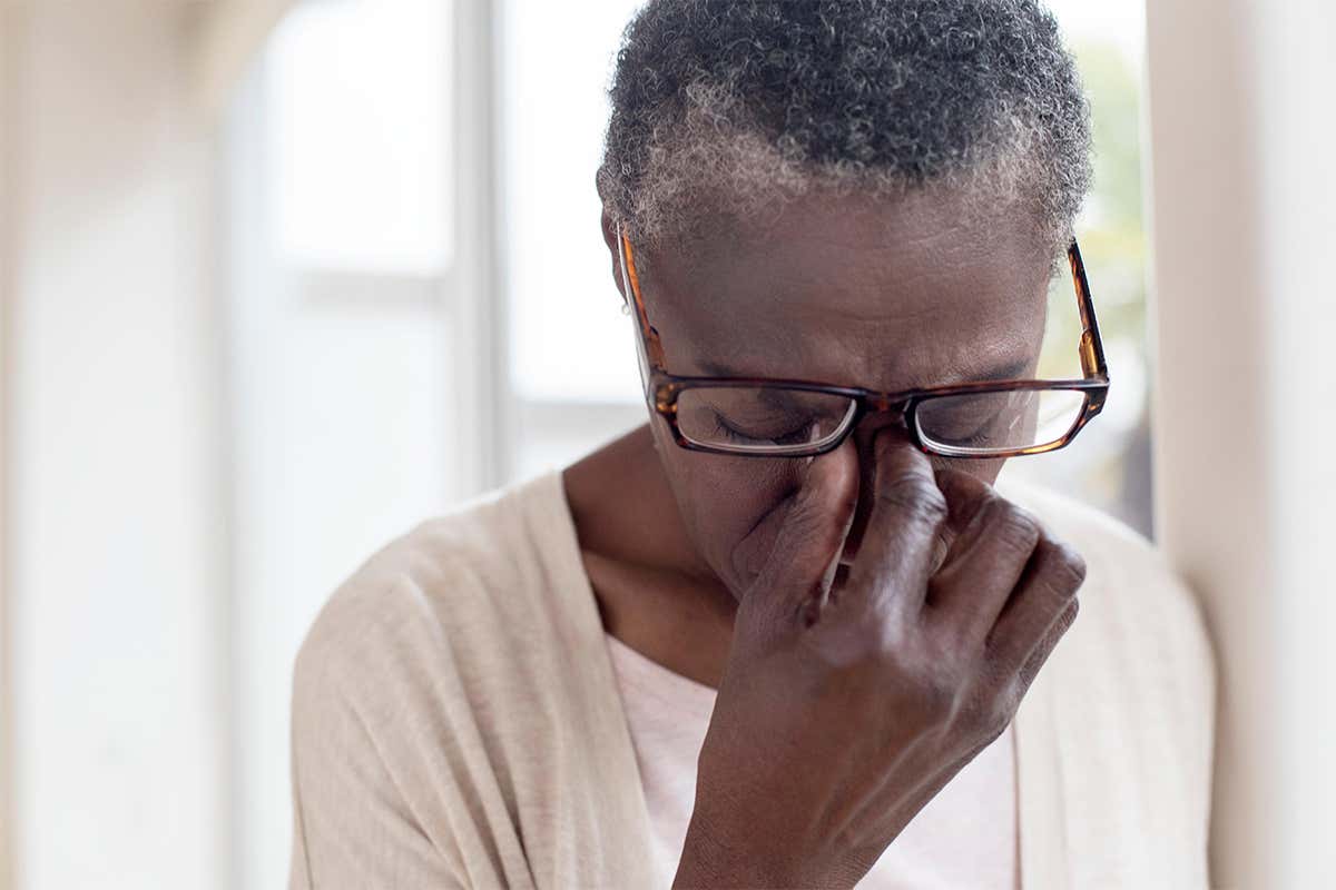 Woman touching bridge of nose (Stress)