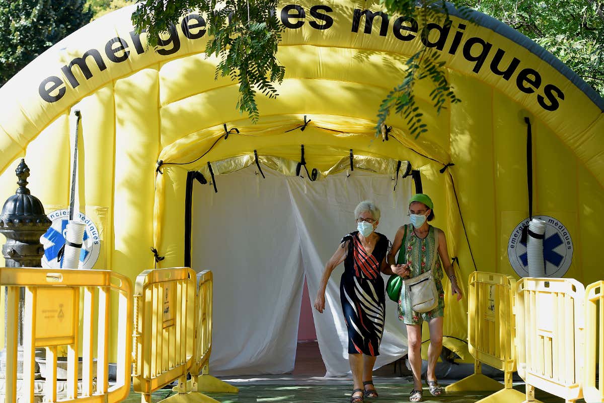 Two women wearing face masks leaving a coronavirus testing tent