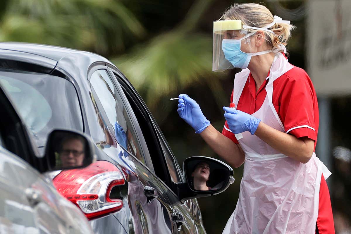 Medical worker takes swab sample in a drive-thru testing centre