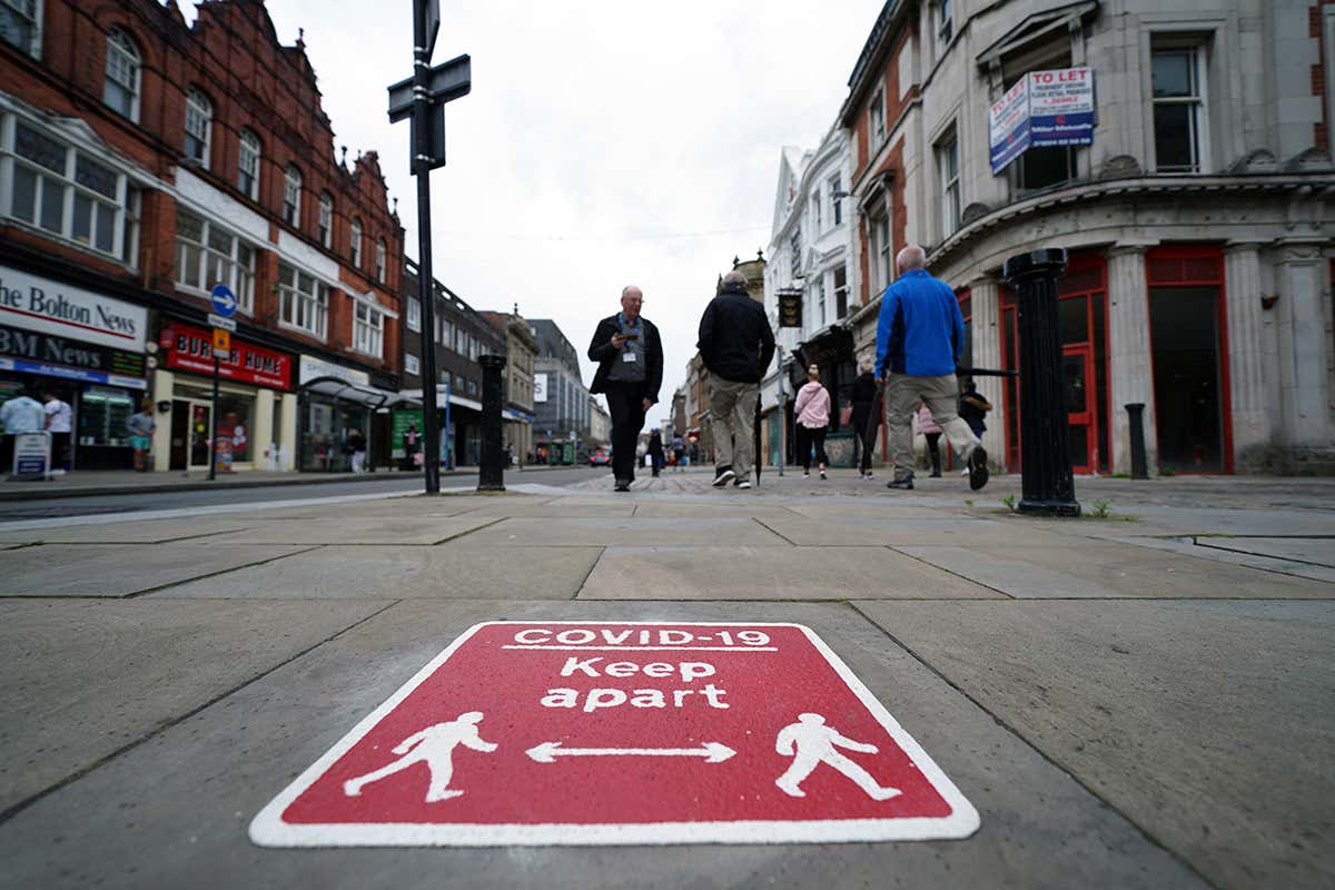 People walk on the street in central Bolton, Greater Manchester