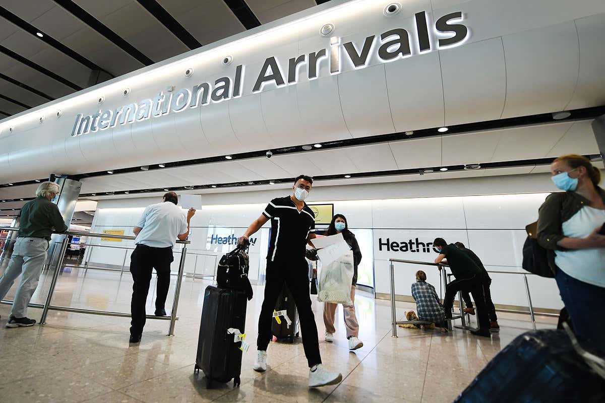 Passengers standing around and walking with suitcases in London's Heathrow airport