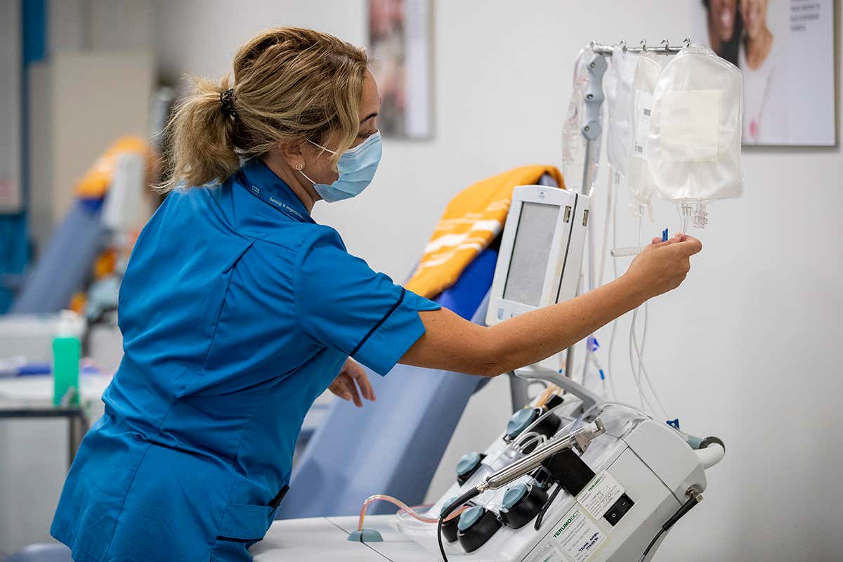 A member of the NHS Liverpool Blood and Transplant staff inside a pop up plasma donor centre in Liverpool, UK