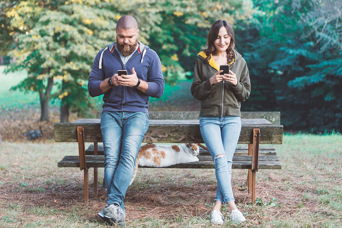 Picture of young couple using smartphones while dating together