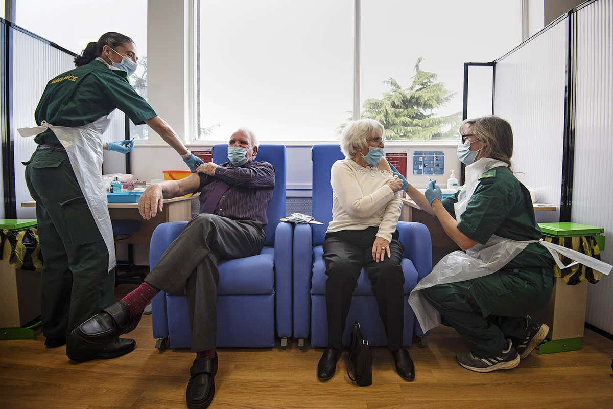 Husband and wife Vic and Penny Griffiths receive the Pfizer/BioNTech covid-19 vaccine at Basildon University Hospital in Essex, England