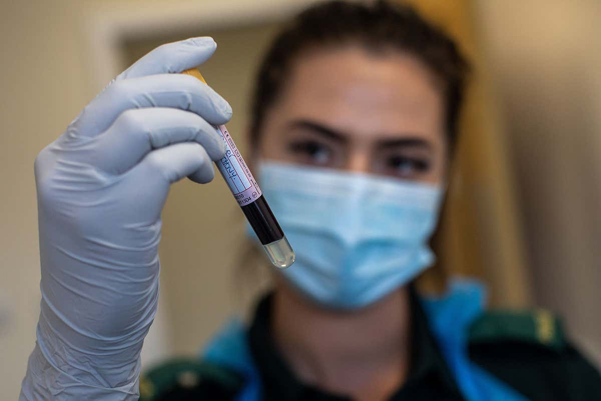A paramedic holds a blood sample during an antibody testing programme at the Hollymore Ambulance Hub of the West Midlands Ambulance Service in Birmingham