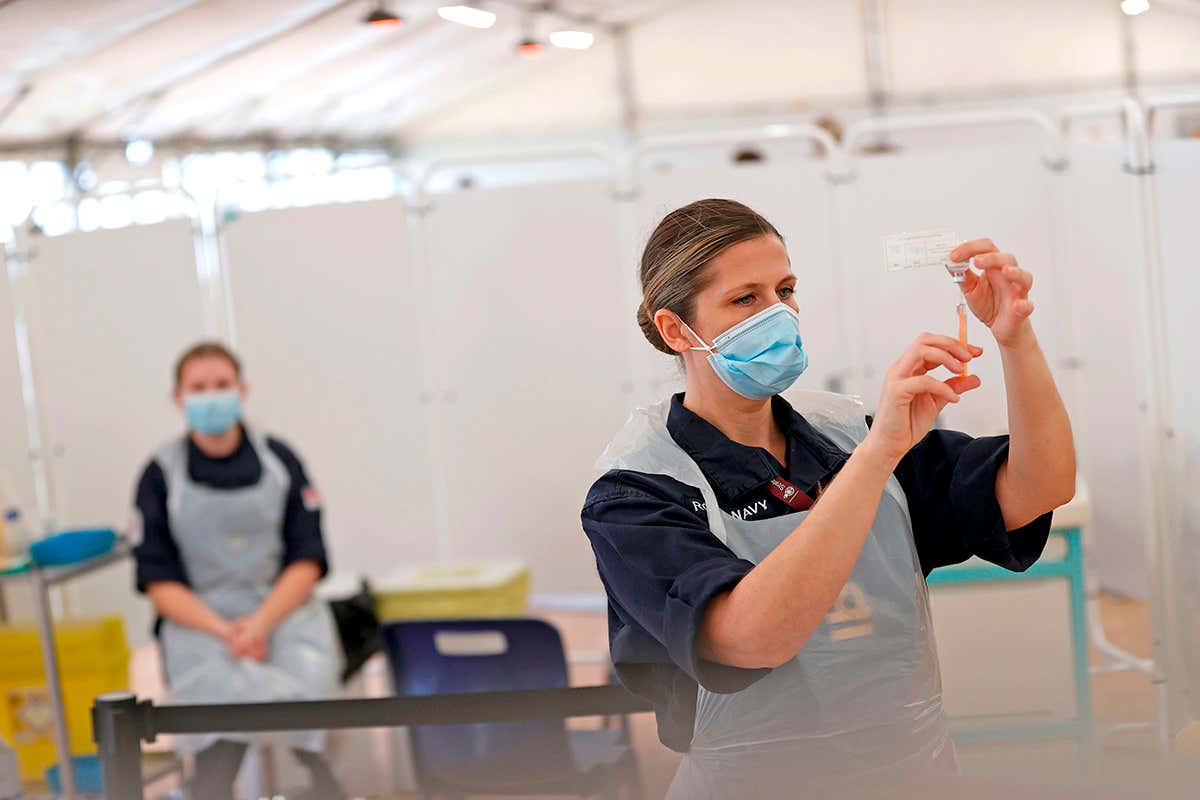Royal Navy medics prepare syringes of the Oxford/AstraZeneca covid-19 vaccine at a vaccination centre