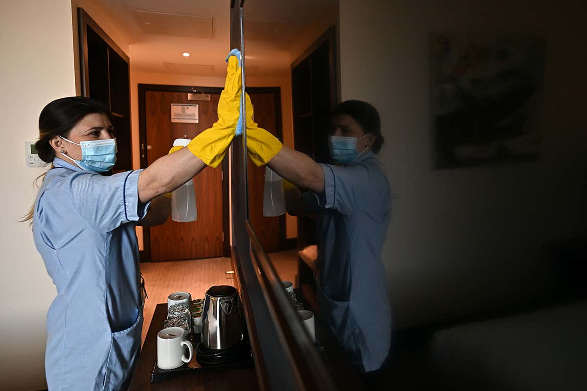 A cleaner wipes a wall inside a quarantine hotel
