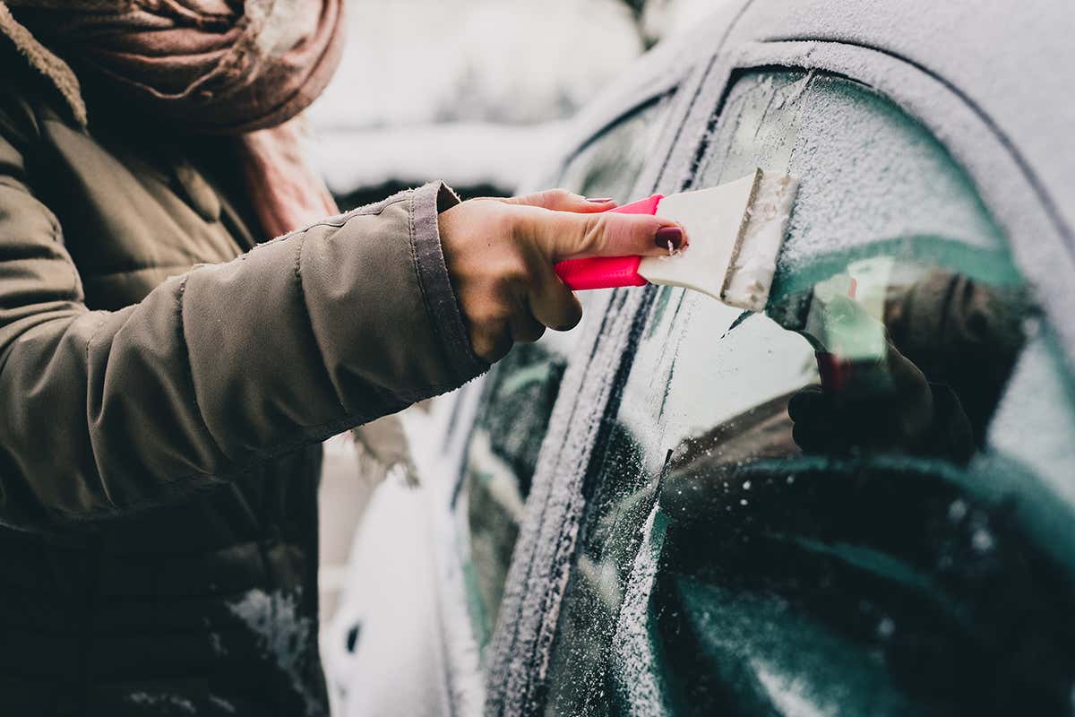 Woman deicing car