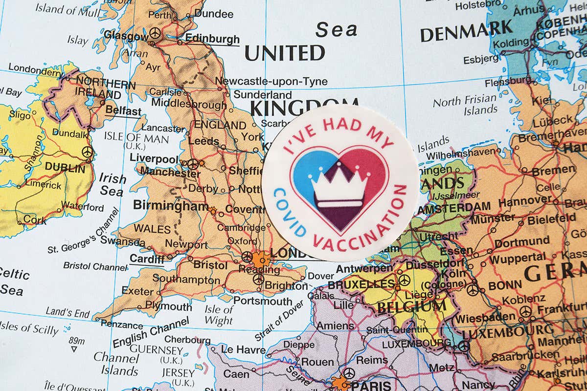 A map featuring the UK with a covid vaccination sticker on top
