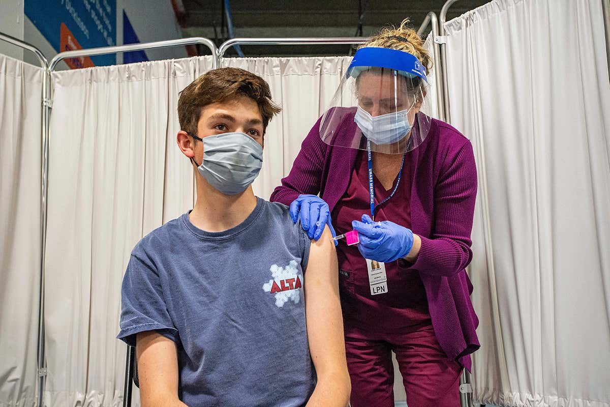 A nurse vaccinates a 16-year-old with the Pfizer/BioNTech covid-19 vaccine in the Mercantile Center in Worcester, Massachusetts