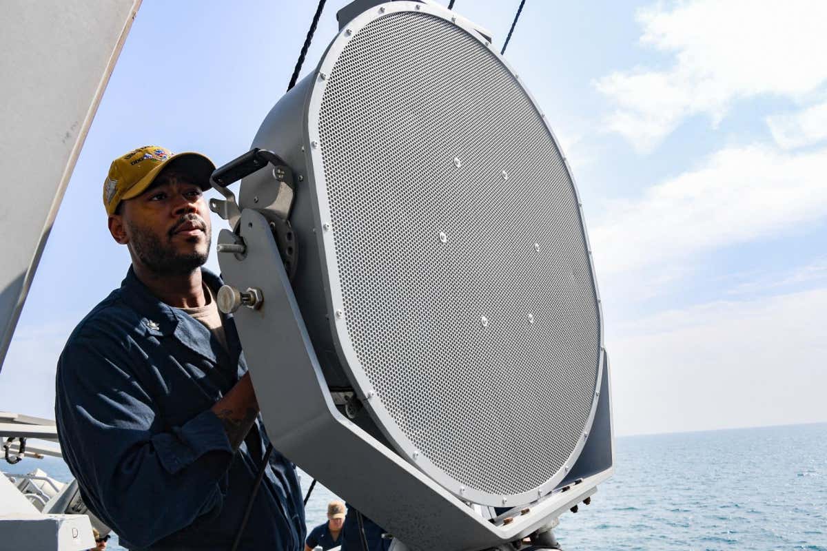 A sailor in the US Navy uses a long-range acoustic device on board a boat