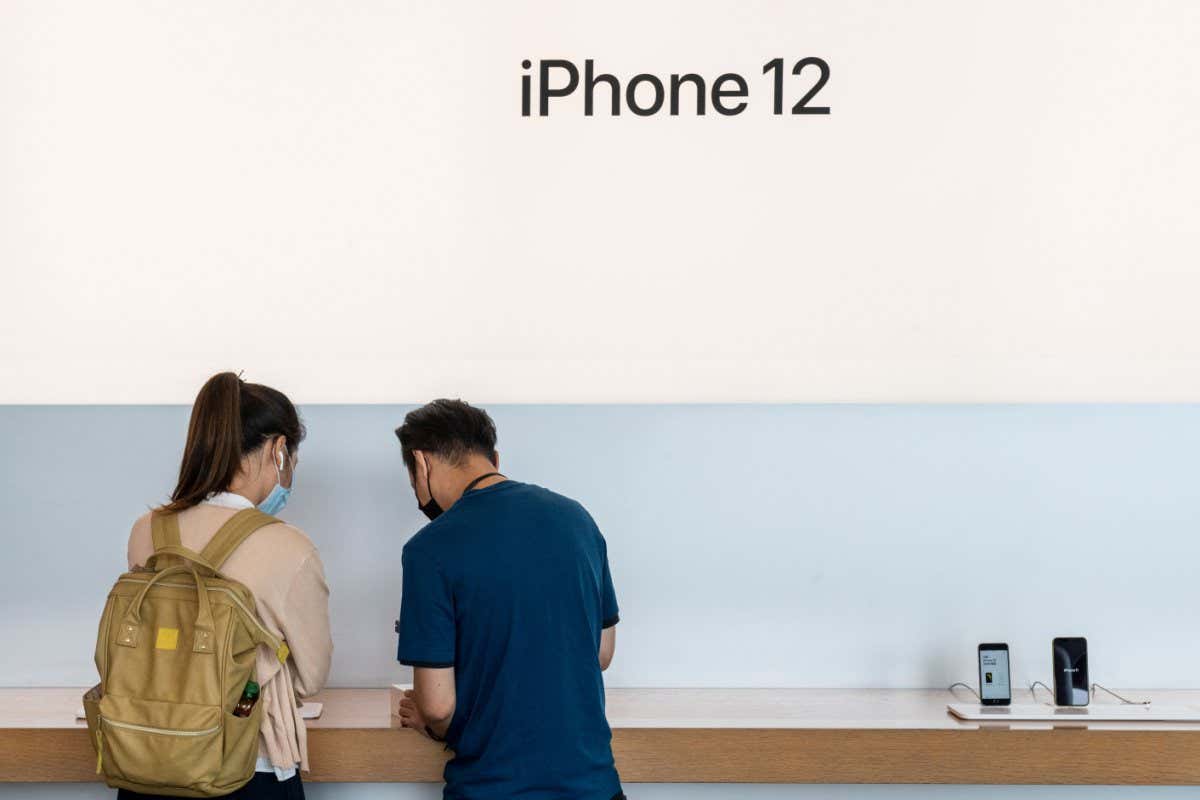 Mandatory Credit: Photo by Budrul Chukrut/SOPA Images/Shutterstock (10973262m) A customer being assisted by an Apple employee as the American technology brand has launched its new iPhone 12 and iPhone 12 Pro smartphones in Hong Kong. Brands and logos in Hong Kong, China - 24 Oct 2020