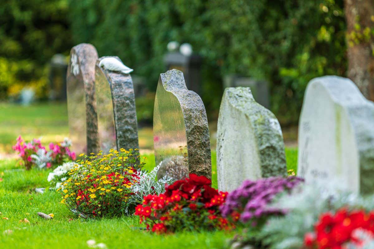 Beautiful summer view of a row of gravestones decorated with colorful flowers at a well-cared cemetery in Sweden; Shutterstock ID 1942445344; purchase_order: -; job: -; client: -; other: -