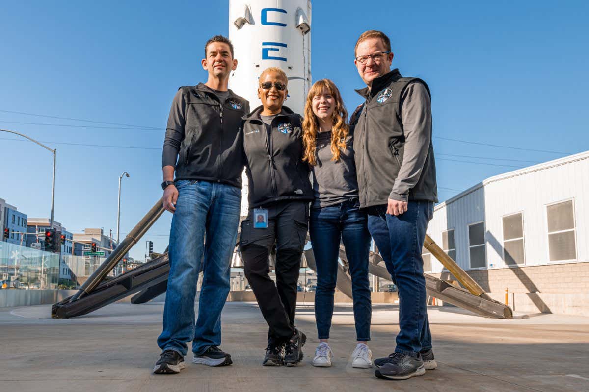Crew standing in front of rocket