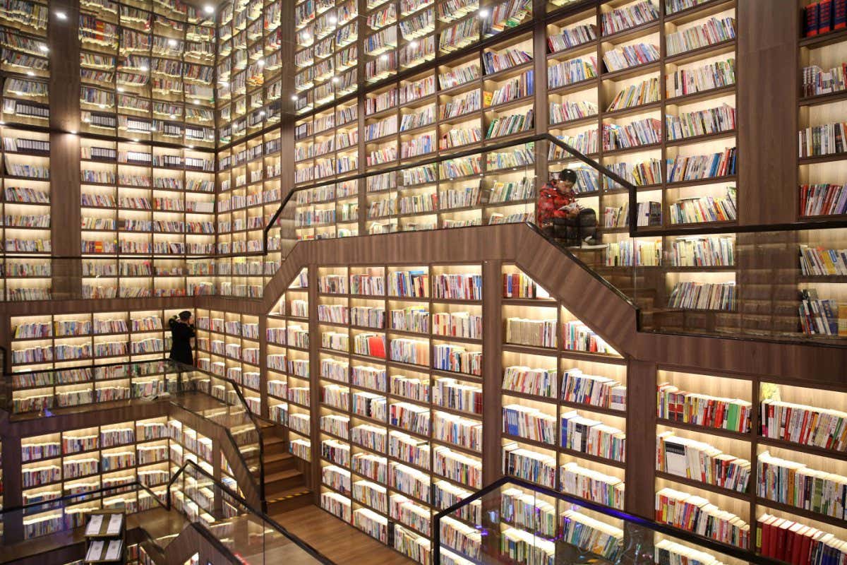 TOPSHOT - This photo taken on January 2, 2021 shows people reading books in a library with a mirrored ceiling in Shaoyang, in China's central Hunan province. (Photo by STR / AFP) / China OUT (Photo by STR/AFP via Getty Images)