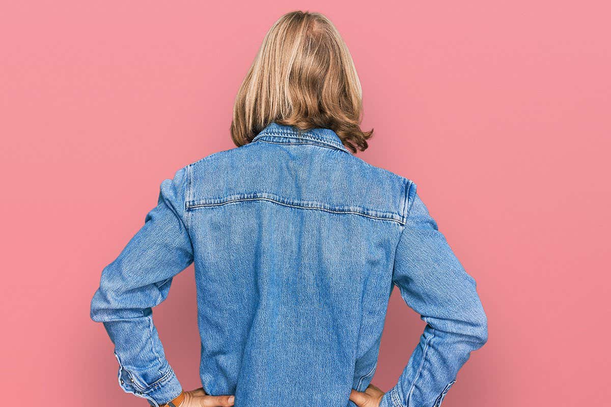 2FWH4MD Caucasian man with blond long hair wearing casual denim jacket standing backwards looking away with arms on body
