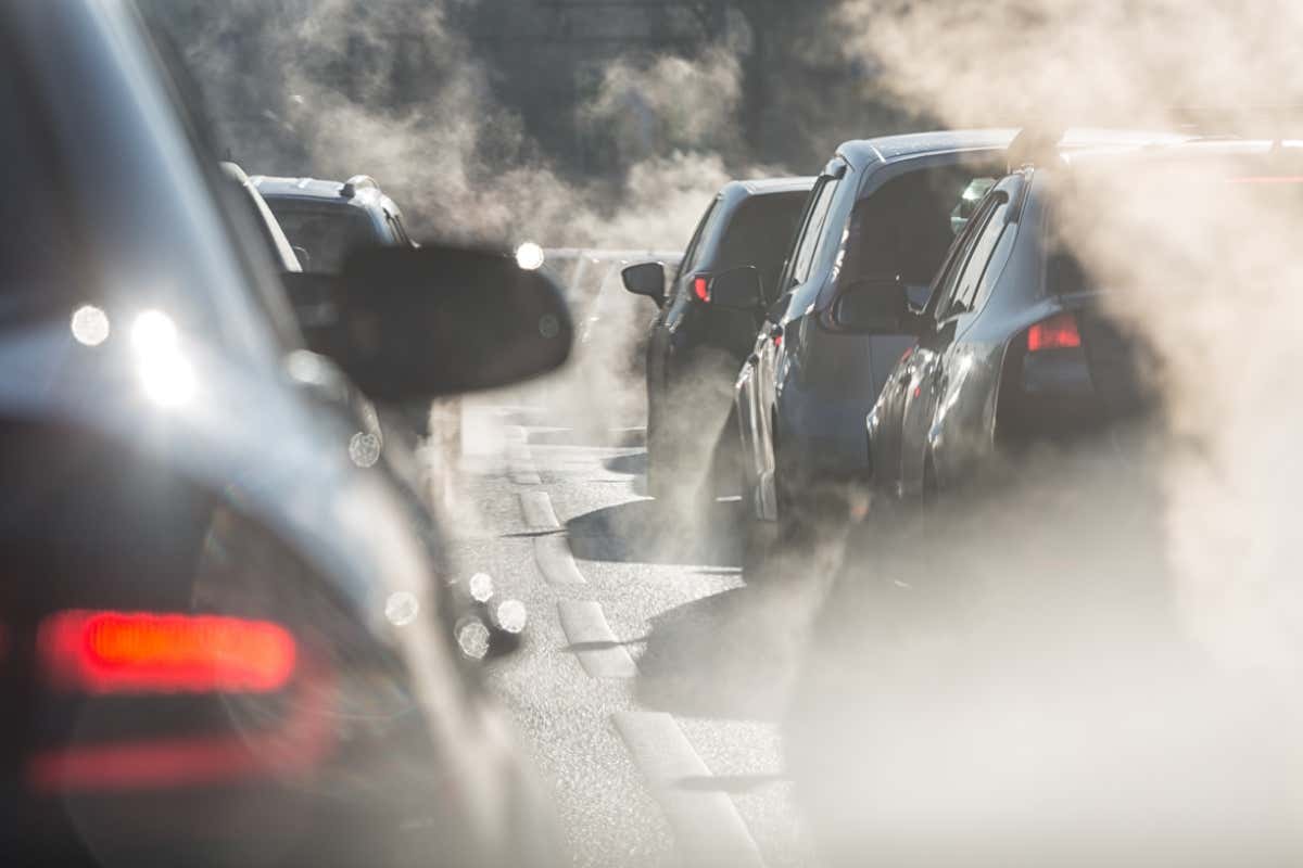 Blurred silhouettes of cars surrounded by steam from the exhaust pipes