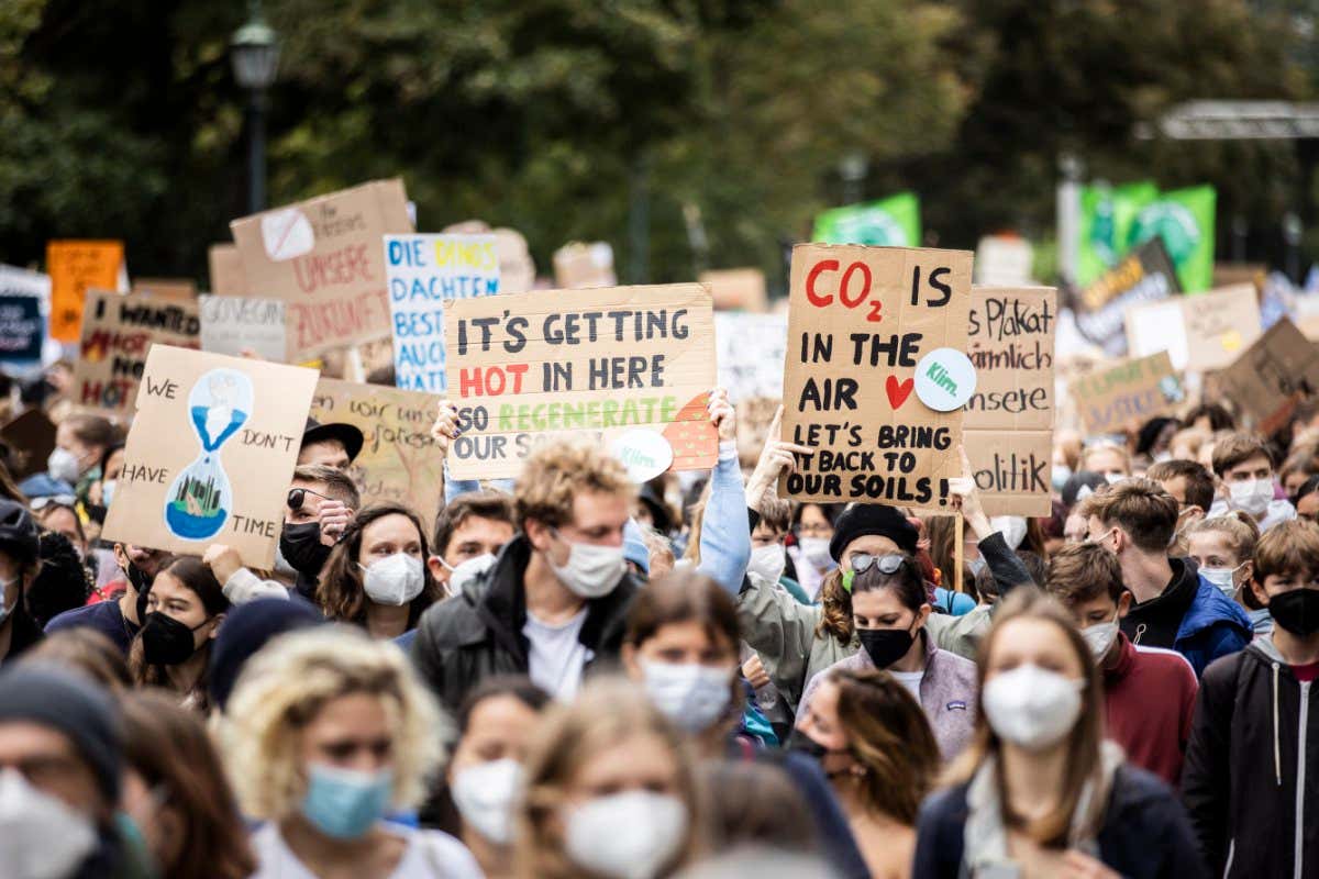 Climate change protesters holding signs in a large crowd