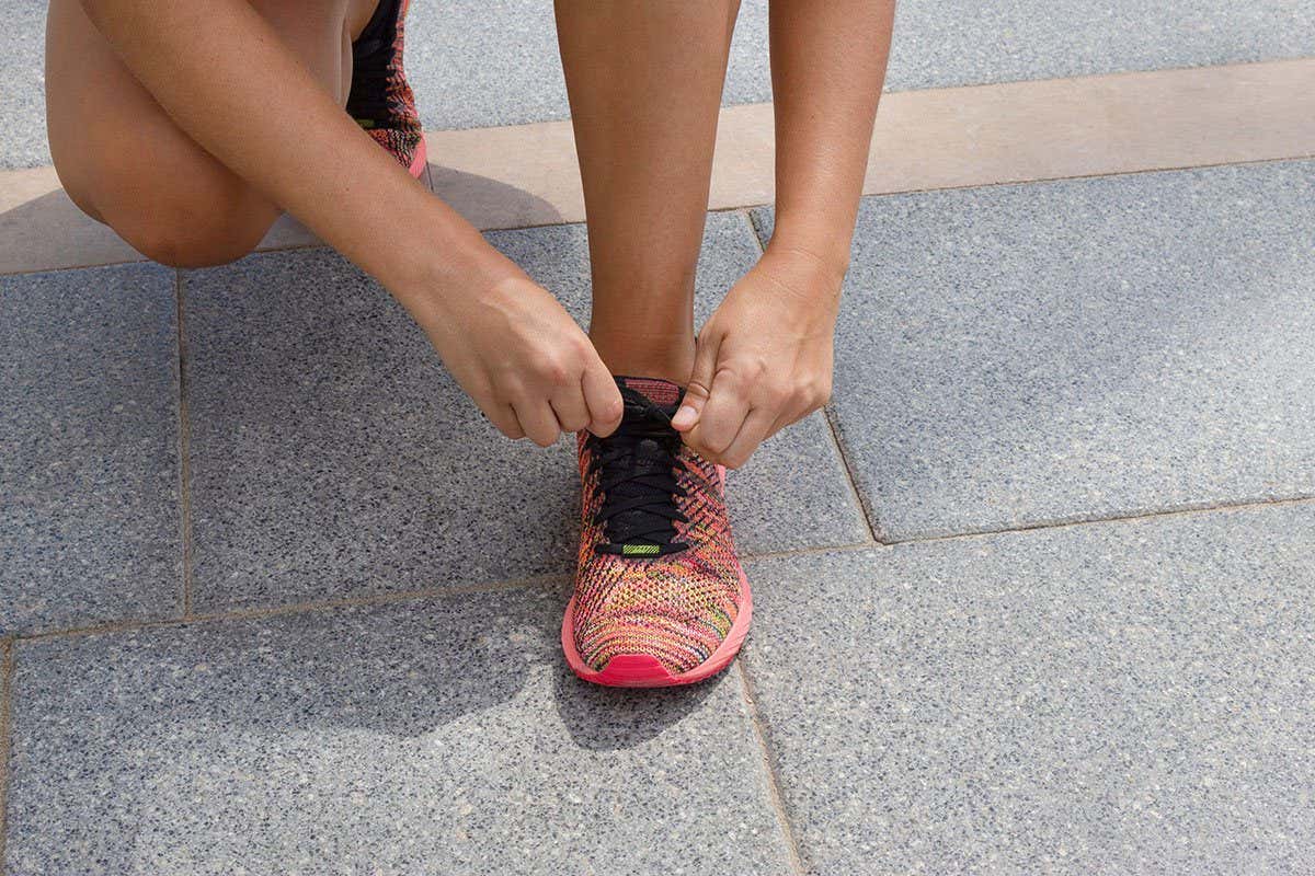 2D4B1M5 Sporty young woman tying the shoelaces before run or jog.Concept of sport and healthy lifestyle.