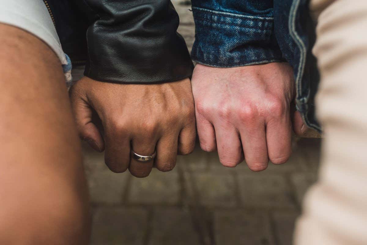 Close-up of gay couple hands on table
