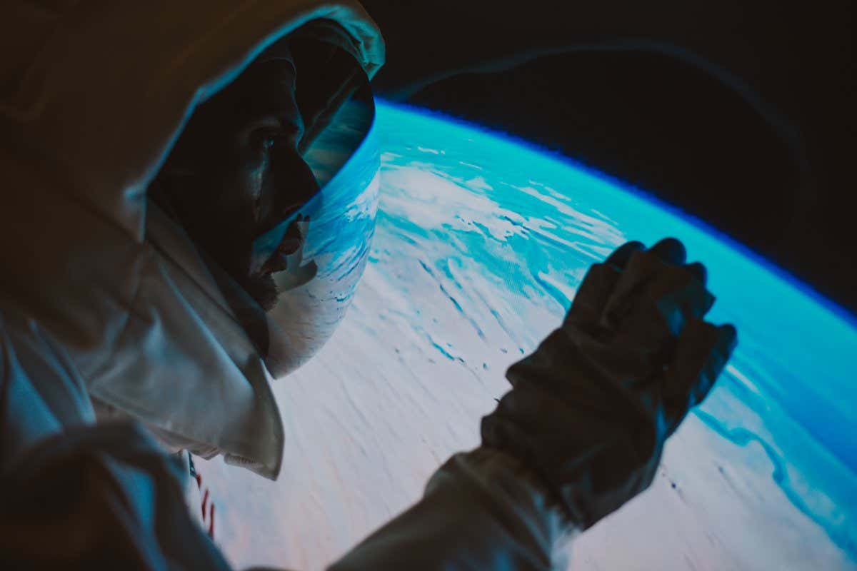 Astronaut looking planet earth from the window of his capsule. Concept about science and space exploration
