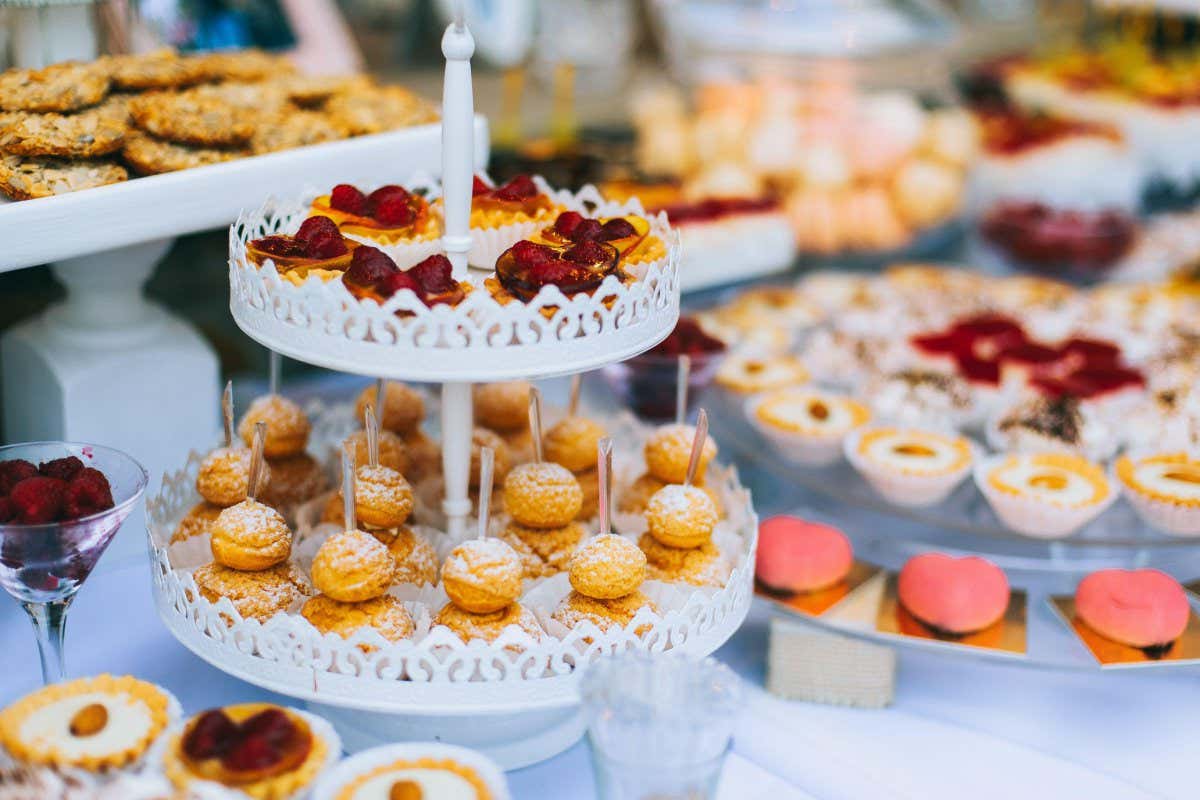 2D6CTBM Wedding candy bar with different colored bright cupcakes, macaroons, cakes, jelly and fruits.