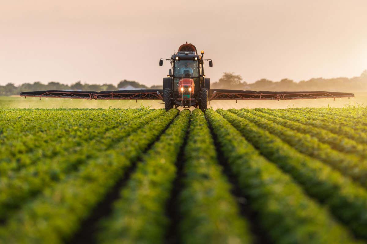 Tractor spraying pesticides on soybean field with sprayer at spring; Shutterstock ID 692043769; purchase_order: -; job: -; client: -; other: -