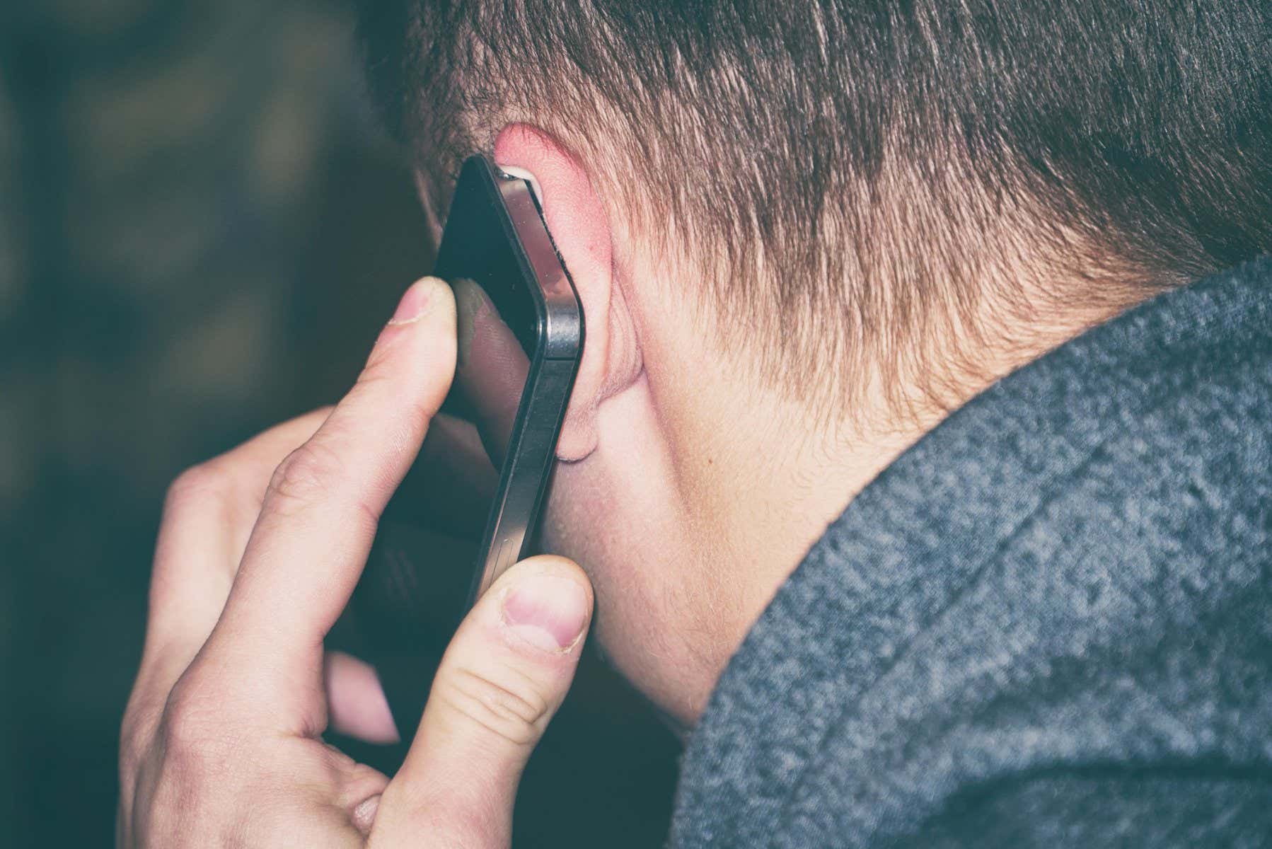 2A3D63T A man talking on the phone. The phone is at the man's ear. Rear view