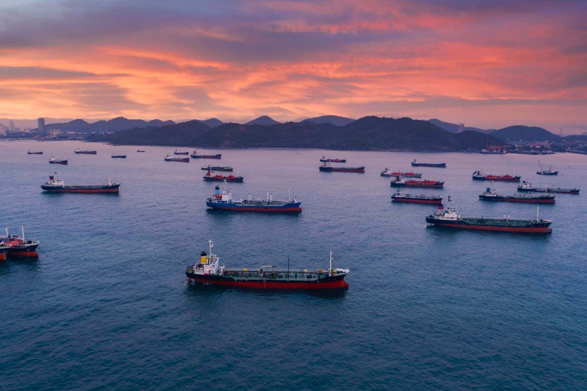 Aerial view Oil ship tanker park on the sea waiting for load or unload oil at loading dock from refinery, Business logistics, import export shipping or freight transportation.