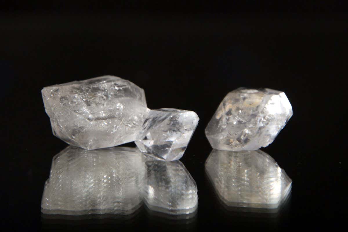 Three cloudy mineral rocks are set against a black background