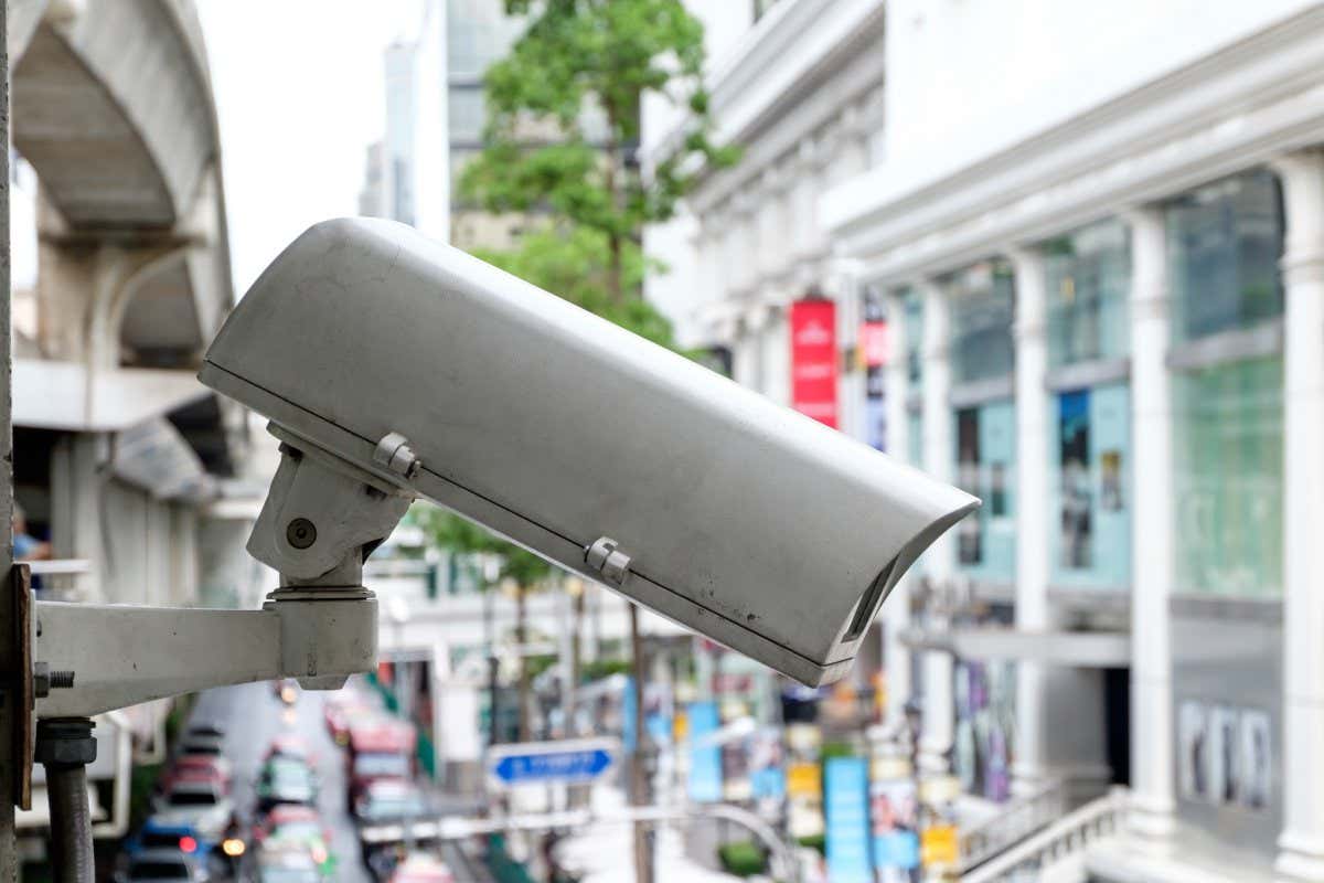 Close up CCTV security camera with blur of traffic jam in the background