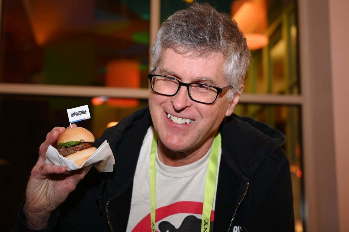 Impossible Foods CEO Pat Brown holds up an Impossible Burger 2.0, the new and improved version of the company's plant-based vegan burger that tastes like real beef, at a press event during CES 2019 in Las Vegas, Nevada on January 7, 2019. - The updated version can be cooked on a grill and has a better flavor and lowered cholesterol, fat and calories than the original. 