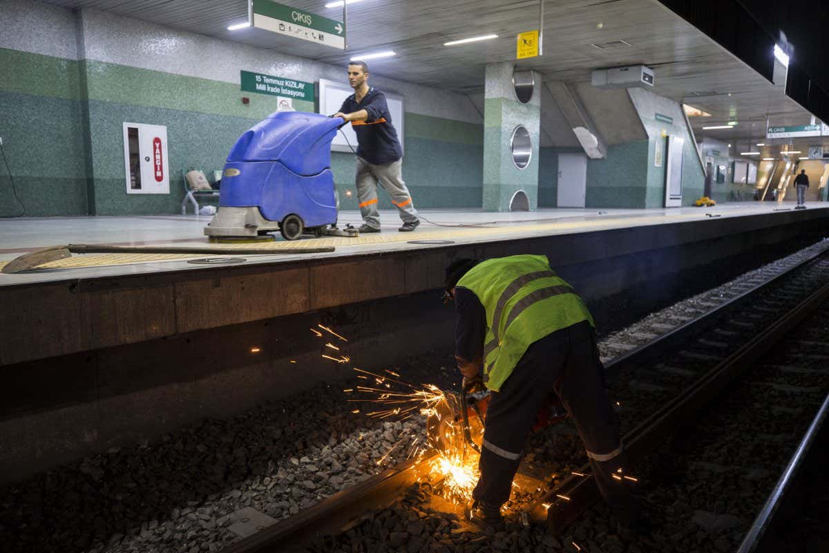 ANKARA, TURKEY - MARCH 31 : A worker uses a metal cutter on a rail on Ankaray subway line during night shift in Ankara, Turkey on March 31, 2018. Long rapid transit line of the Ankara Metro system has been operating for 23 years. Ankaray operates approximately 180 runs on daily basis, with 11 cars. Length of the transit line reaches about 9 kilometers. Night shift workers compete against time while cutting old rails and replacing them with the new ones until the first run in the morning. (Photo by Mustafa Kamaci/Anadolu Agency/Getty Images)