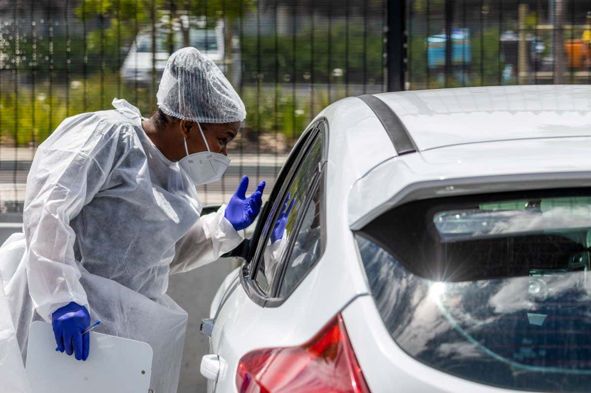 A health worker speaks with a driver in the drive-thru area of the Testaro Covid-19 mobile testing site outside Richmond Corner shopping center in the Milnerton district of Cape Town, South Africa, on Thursday, Dec. 2, 2021. South Africa announced the discovery of a new variant, later christened omicron, on Nov. 25 as cases began to spike and the strain spread across the globe. Photographer: Dwayne Senior/Bloomberg via Getty Images