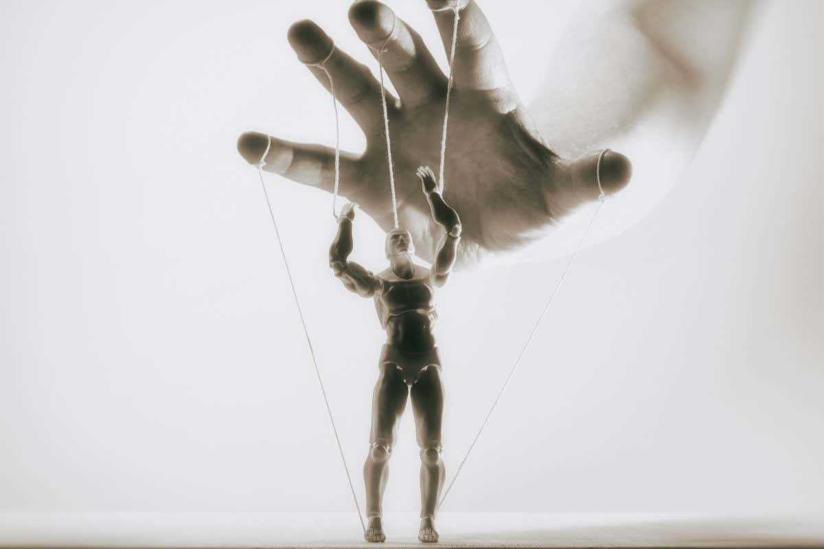 Concept of control. Marionette in human hand. Black and white image.; Shutterstock ID 1670191051; purchase_order: -; job: -; client: -; other: -