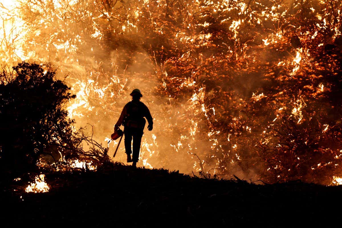 A firefighter works as the Caldor Fire burns in Grizzly Flats, California, U.S., August 22, 2021. REUTERS/Fred Greaves TPX IMAGES OF THE DAY - RC2RAP9BI0EP