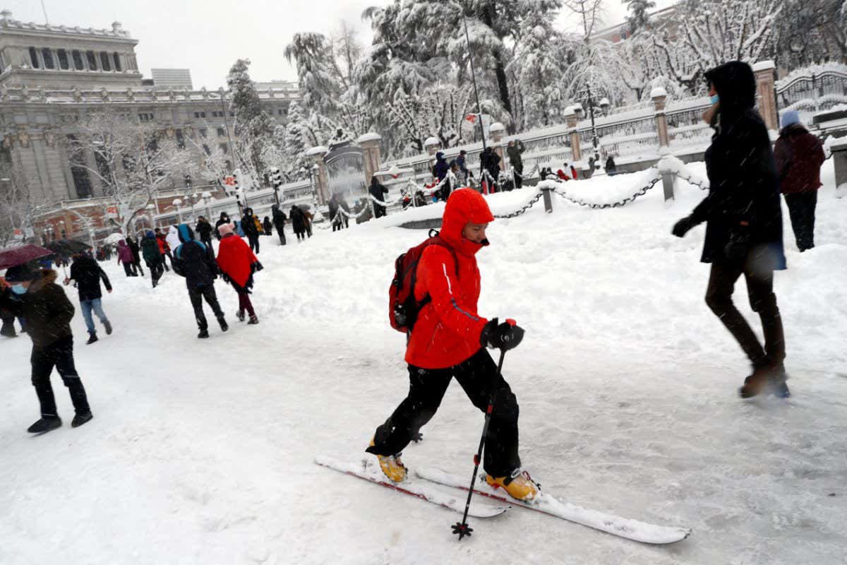 People walk and ski downtown during a heavy snowfall in Madrid, Spain January 9, 2021. REUTERS/Susana Vera - RC2E4L9LL5NE