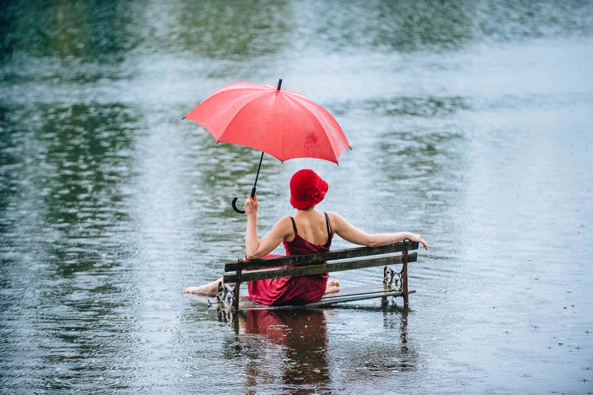 Woman sitting on bench in flood