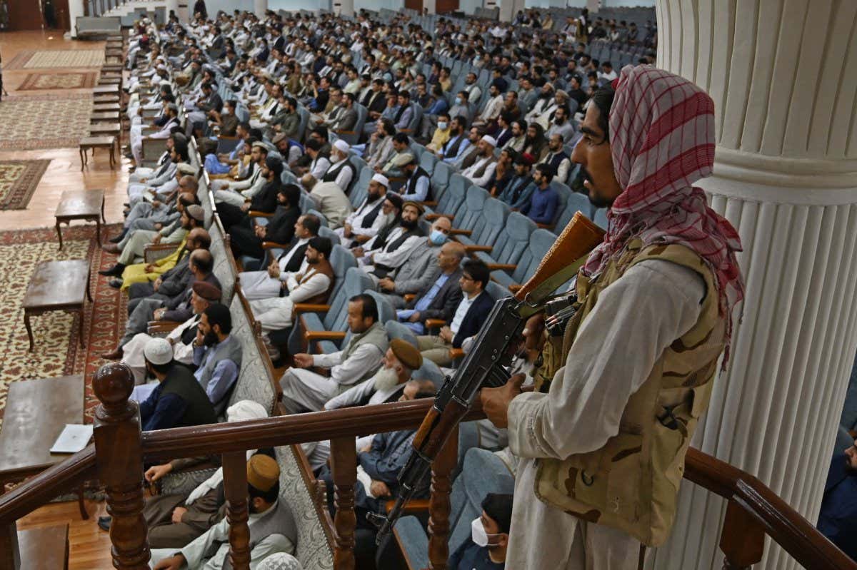 Taliban fighter standing guard over meeting