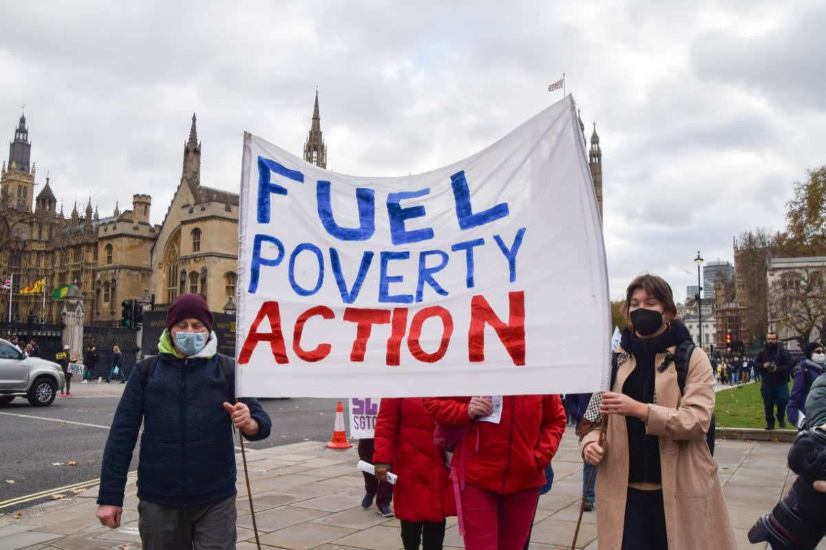LONDON, UNITED KINGDOM - 2021/11/26: Protesters march with a Fuel Poverty Action banner during the demonstration in Parliament Square. Protesters gathered outside the Houses of Parliament and marched to Downing Street to deliver a letter to Boris Johnson, demanding action on excess winter deaths. Tens of thousands of people, particularly the oldest and poorest, die each year due to cold homes and the inability to afford heating. (Photo by Vuk Valcic/SOPA Images/LightRocket via Getty Images)