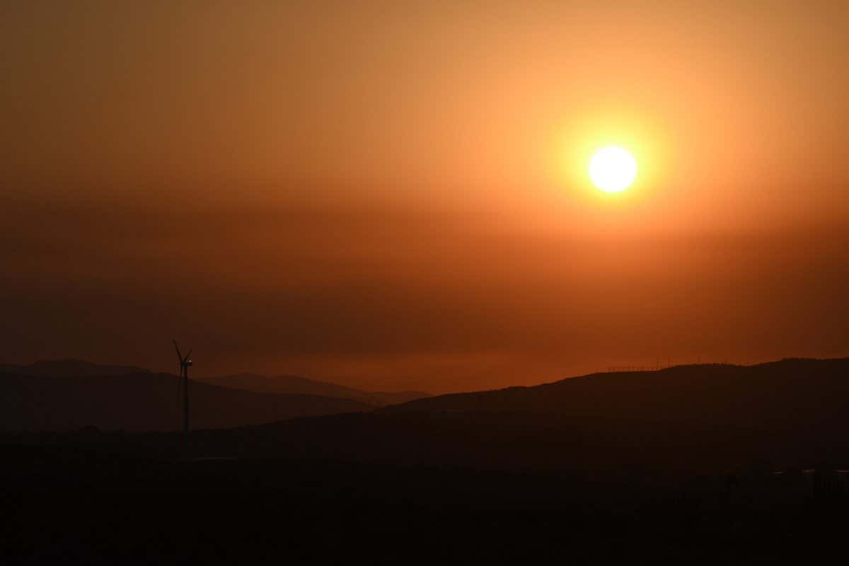 TOPSHOT - The sun sets near a windmill in Palmdale, California where temperatures reached 106 degree Fahrenheit (41.1 degrees Celsius) today, July 12, 2021. - Wildfires were burning across more than one million acres of the western United States and Canada on Monday, as scorching temperatures held their grip on areas reeling from a brutal weekend heat wave. (Photo by Robyn Beck / AFP) (Photo by ROBYN BECK/AFP via Getty Images)