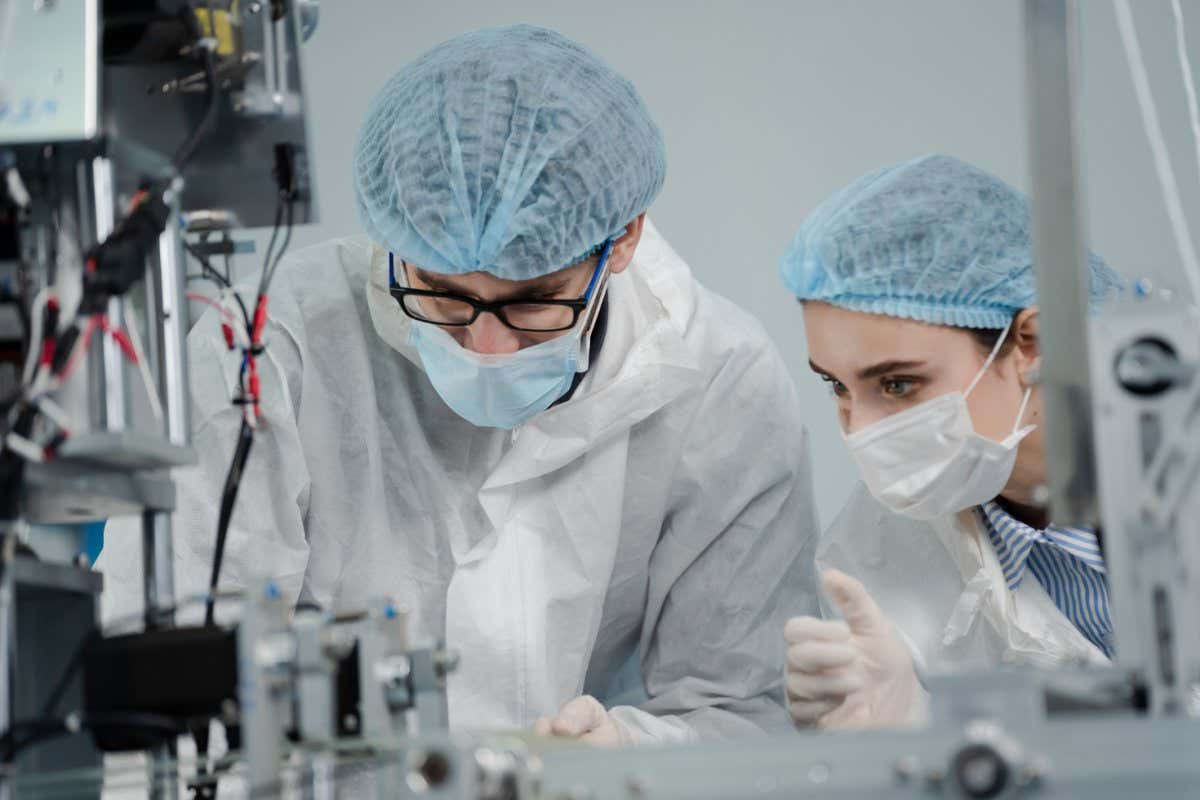 Medical mask factory, a team of medical professionals, a wide range of industries, programming and manipulation of high-tech facility robots Scientist Sterile clothing, lab work; Shutterstock ID 1879741264; purchase_order: -; job: -; client: -; other: -