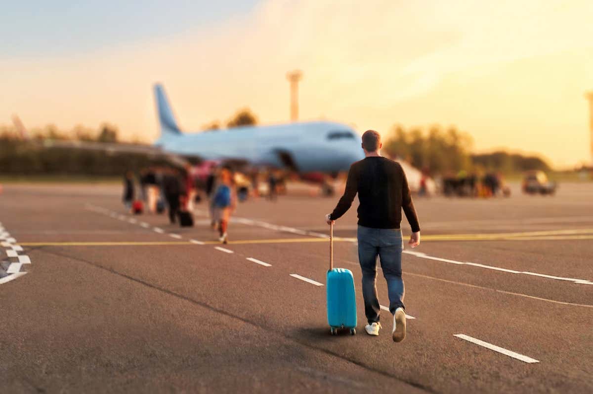 man walking towards a passenger plane