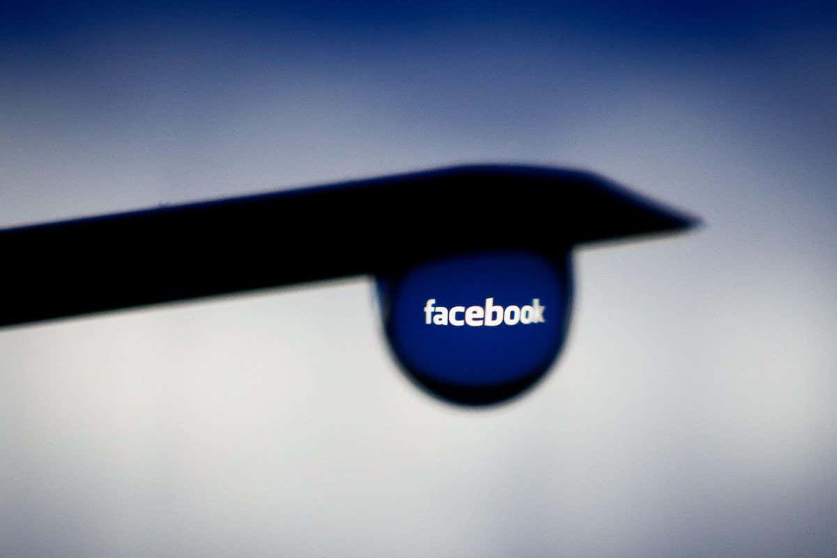 2EYNNFD The Facebook logo is seen reflected in a drop hanging from a needle in this photo illustration in Warsaw, Poland on March 4, 2021. As part of its policy on COVID-19-related misinformation, Facebook will start removing posts with false claims about vaccines. (Photo by Jaap Arriens / Sipa USA)