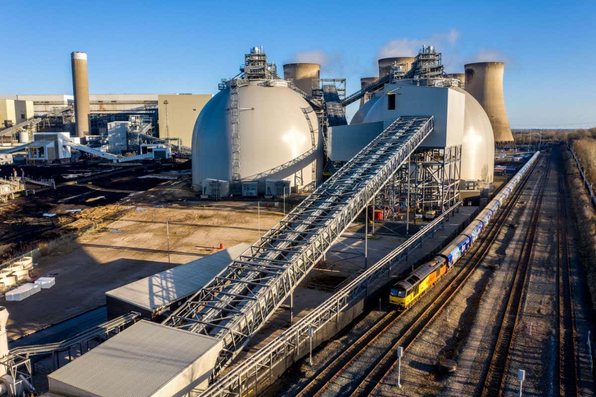 2HJF0FC DRAX POWER STATION, DRAX, UK - JANUARY 19, 2022. An aerial view of a rail freight train delivering renewable biomass fuel to Drax Power Station