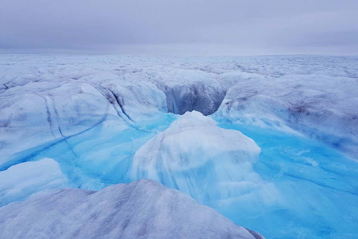 Water flowing into a moulin and down to the bed of Store Glacier