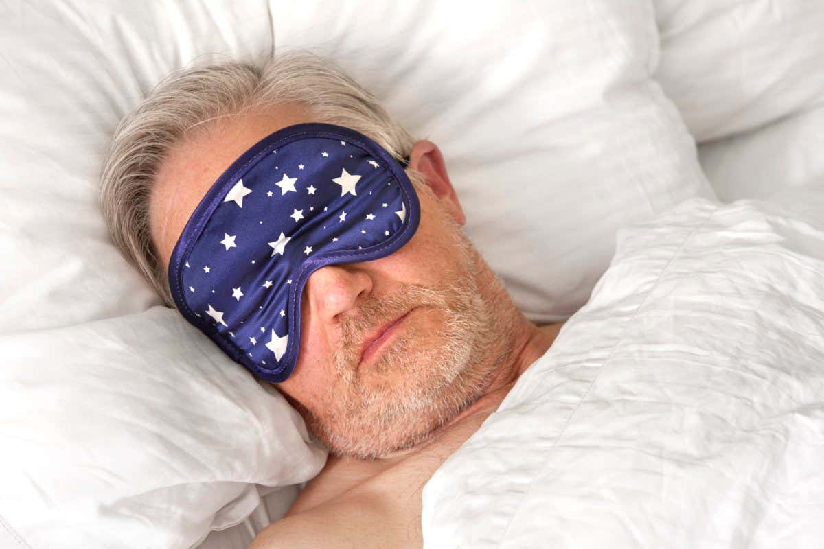 Mature man sleeping wearing eye mask close up