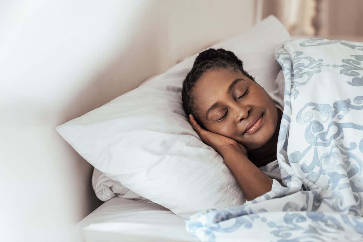Content young African woman sleeping peacfully under a duvet in her bed at home in the early morning; Shutterstock ID 763309252; purchase_order: -; job: -; client: -; other: -